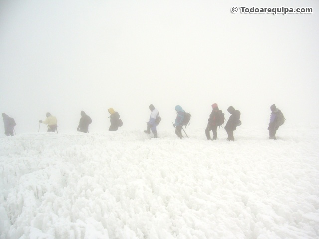 Caminando en fila sobre la nieve del Coropuna con neblina